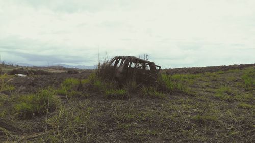 Abandoned barn on field against sky