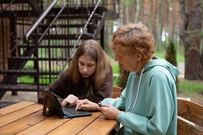 Young woman using laptop while sitting at park