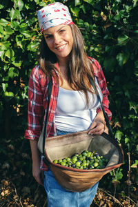 Young woman holding ice cream standing by plants