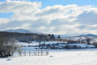 Scenic view of snow covered field against sky