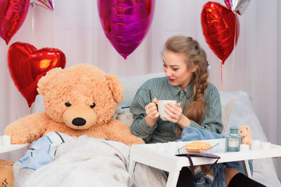 Young woman sitting with toys at home