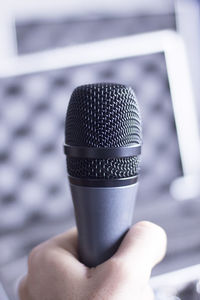 Close-up of human hand holding microphone