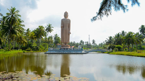 Large buddha statue with lake in foreground