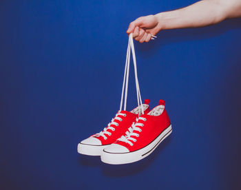 Close-up of red hand against blue background