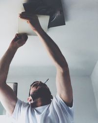 Man smoking cigarette while opening ceiling