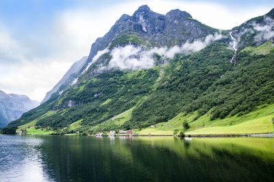 Scenic view of lake by mountains against sky