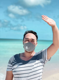 Portrait of man standing in sea against sky