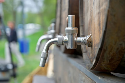 Close-up of faucet against beer kegs