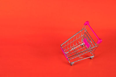 Low angle view of illuminated red and pink art against orange background