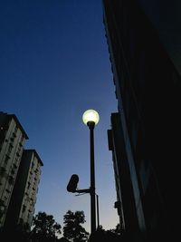 Low angle view of illuminated street light against sky at dusk