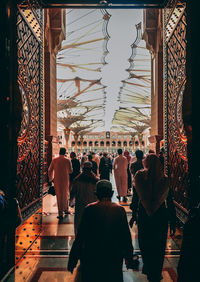 Rear view of people at temple against building