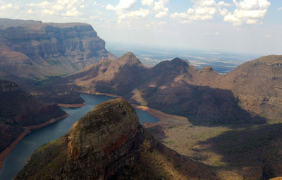 Scenic view of sea and mountains against sky