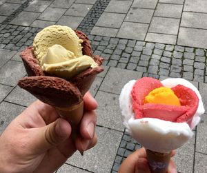 Midsection of person holding ice cream cone on footpath
