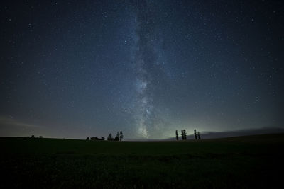 Scenic view of silhouette field against sky at night