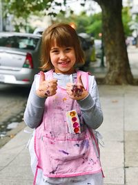 Portrait of happy girl holding pink outdoors