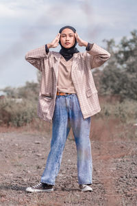 Portrait of teenage girl standing on field