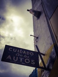 Low angle view of road sign against sky