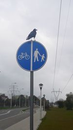 Road sign against blue sky