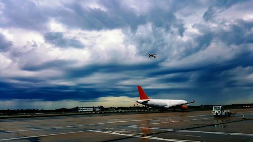 Airplane wing against cloudy sky