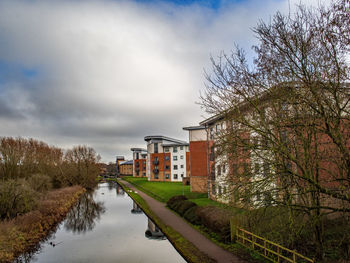 Canal amidst buildings against sky