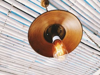 Low angle view of light bulb hanging on ceiling