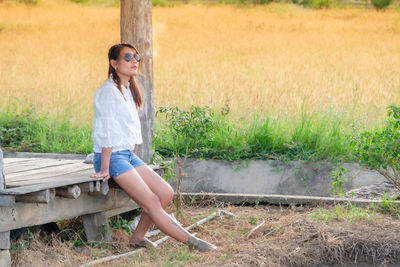 Full length of woman sitting on field