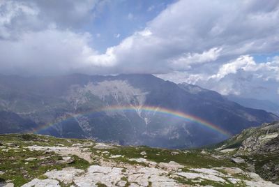 Scenic view of rainbow over mountains against sky