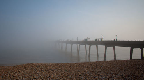 Bridge over sea against clear sky