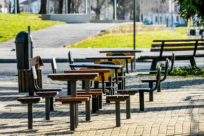 Empty chairs and table on footpath