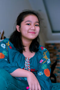 Portrait of smiling woman sitting at home