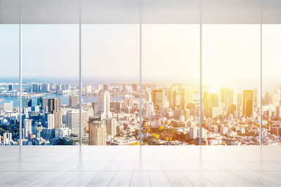 Cityscape seen through glass window during sunset