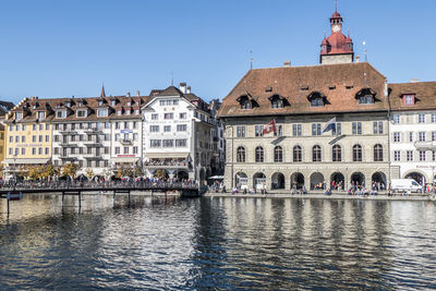 Buildings in city against clear blue sky