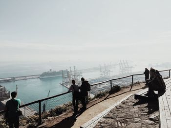 Rear view of people looking at sea against sky