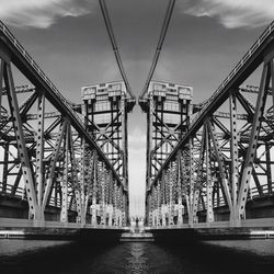 Low angle view of bridge against cloudy sky