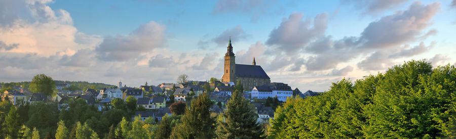 Panoramic view of trees and buildings against sky