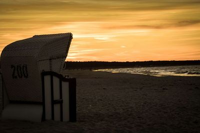 Scenic view of sea against cloudy sky at sunset