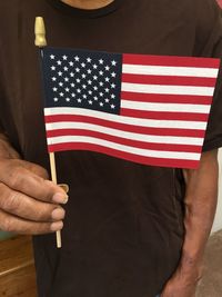 Midsection of man holding american flag