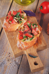 Italian bruschetta with chopped tomatoes, basil, herbs and olive oil on grilled crusty bread