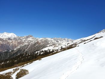 Snowcapped mountains against clear blue sky