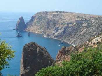 Scenic view of sea and mountains against clear sky