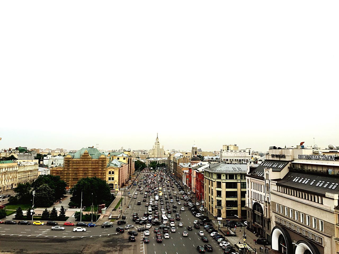 building exterior, architecture, car, built structure, city, transportation, land vehicle, street, clear sky, road, high angle view, mode of transport, copy space, cityscape, city life, city street, residential district, traffic, residential building, residential structure