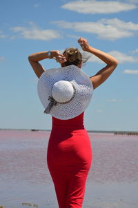 Woman standing at beach against sky