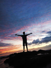 Rear view of silhouette man standing against sky during sunset