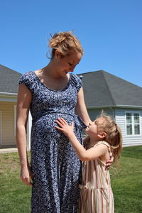 Portrait of young woman standing against sky