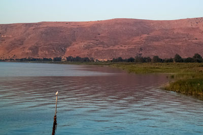 Scenic view of lake by mountain against sky