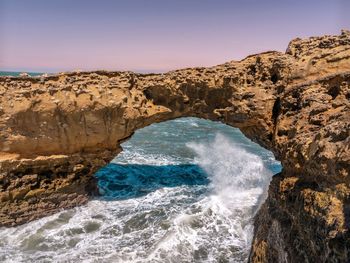 Scenic view of rocks in sea against sky