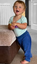 Portrait of cute boy sitting on sofa at home