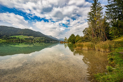 Scenic view of lake by trees against sky