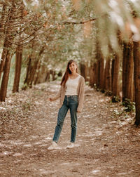 Portrait of a girl with brown hair, in a cardigan, on a walk in the forest.