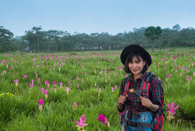 Beautiful young woman standing on field